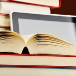 Composition with books and tablet computer on the table.