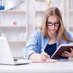 Young teenage female student preparing for exams at home