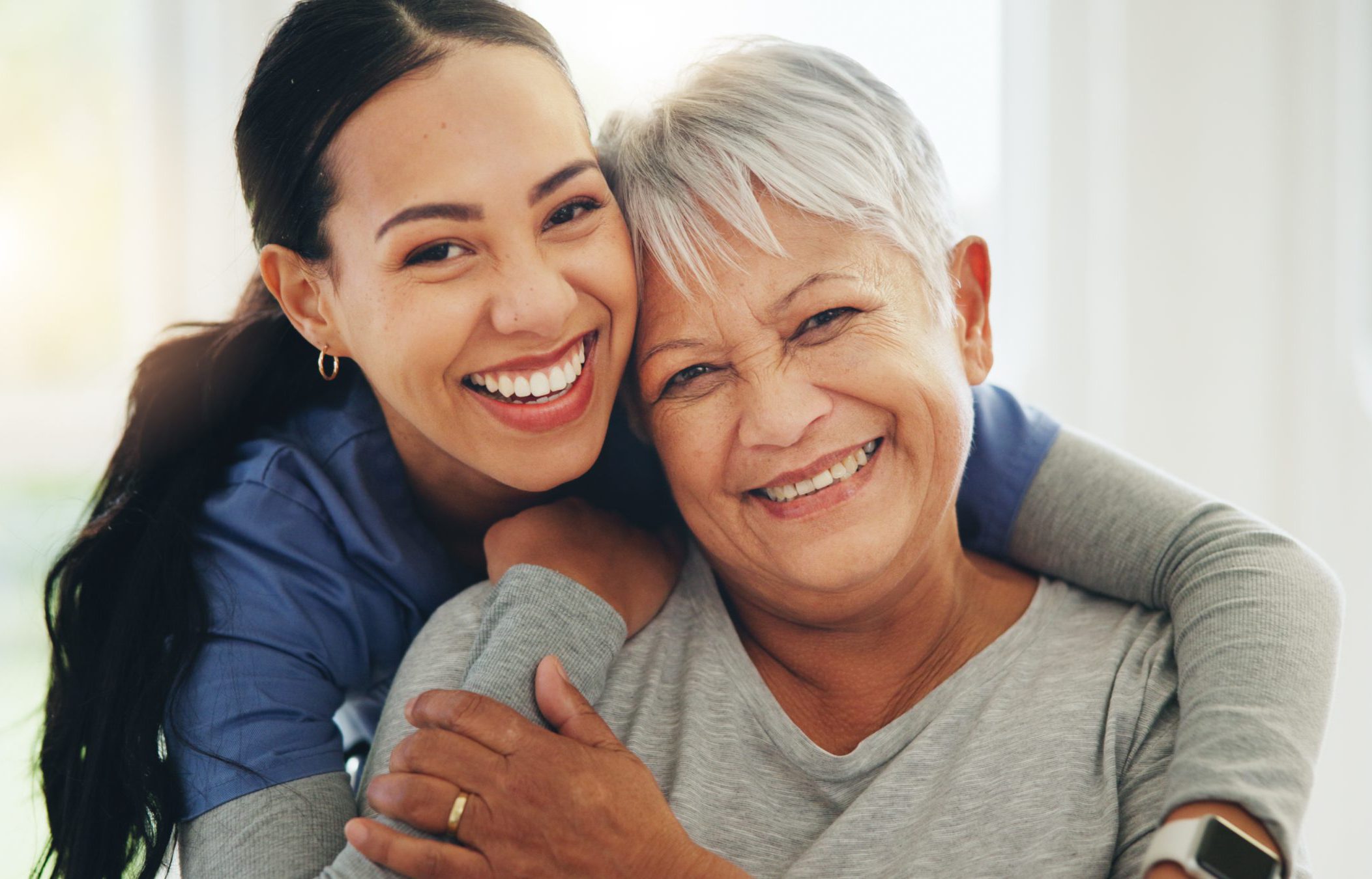 Happy woman, nurse and hug senior patient in elderly care, support or trust at old age home. Portrait of mature female person, doctor or medical caregiver hugging with smile for embrace at house